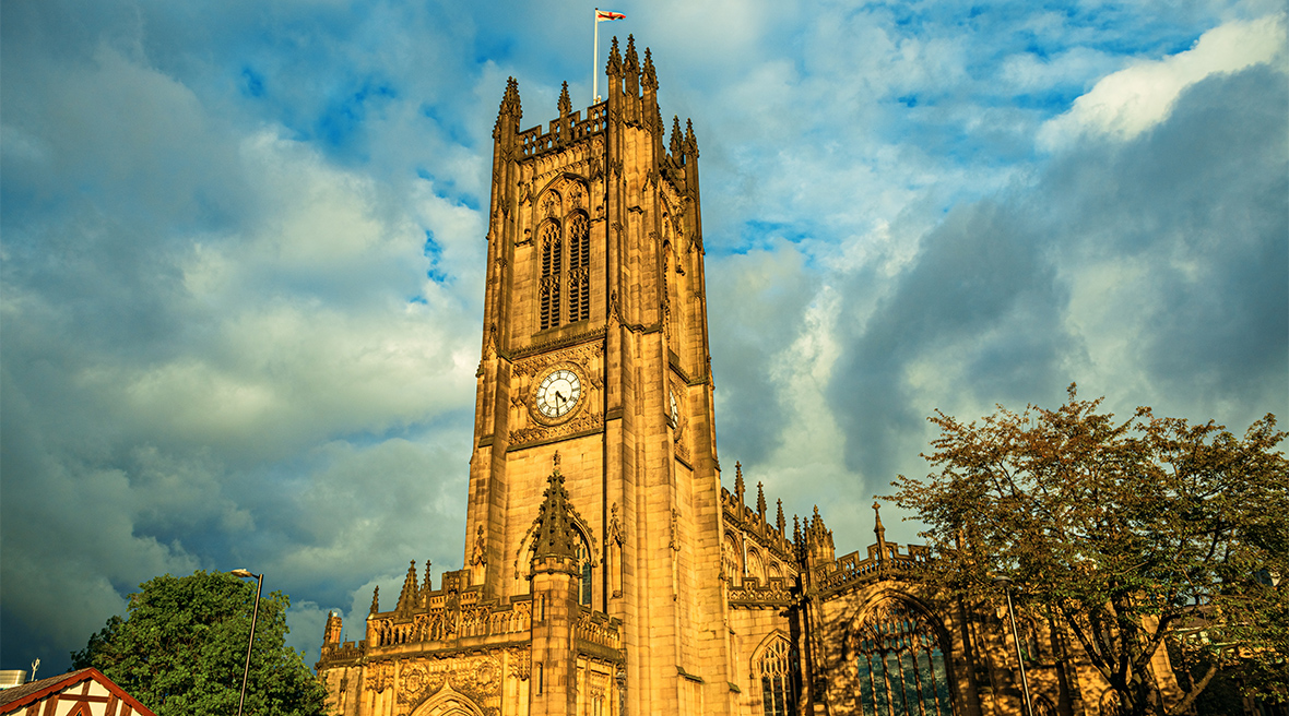 Cathédrale de Manchester éclairée au crépuscule sous un ciel nuageux